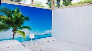 Une chambre avec deux lits, une table de chevet, une lampe et une fresque murale représentant une scène de plage.