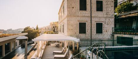 Een buitenzwembad en ligstoelen