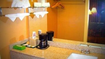 A hotel bathroom with a sink, towel rack, and a mirror.