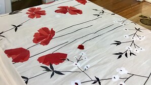 Ein Schlafzimmer mit Bett, Glastisch, Kamin und einer mit Vorhängen versehenen Tür.
