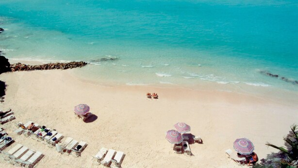 A beach with clear turquoise water, sun loungers, and umbrellas. - Pompano Beach Club (Southampton Parish)