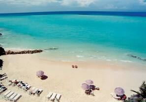 Praia particular, areia branca, espreguiçadeiras, guarda-sóis 