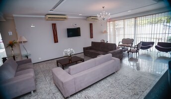 Una sala moderna con un sofá, sillones, una mesa de centro y un televisor.