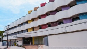 Un edificio moderno con una fachada ondulada distintiva, varios balcones y una entrada visible.