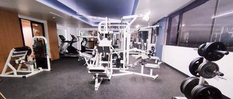 A gym with various exercise equipment, including weight machines and free weights.