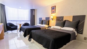 Habitación de hotel con dos camas, un escritorio y una silla.