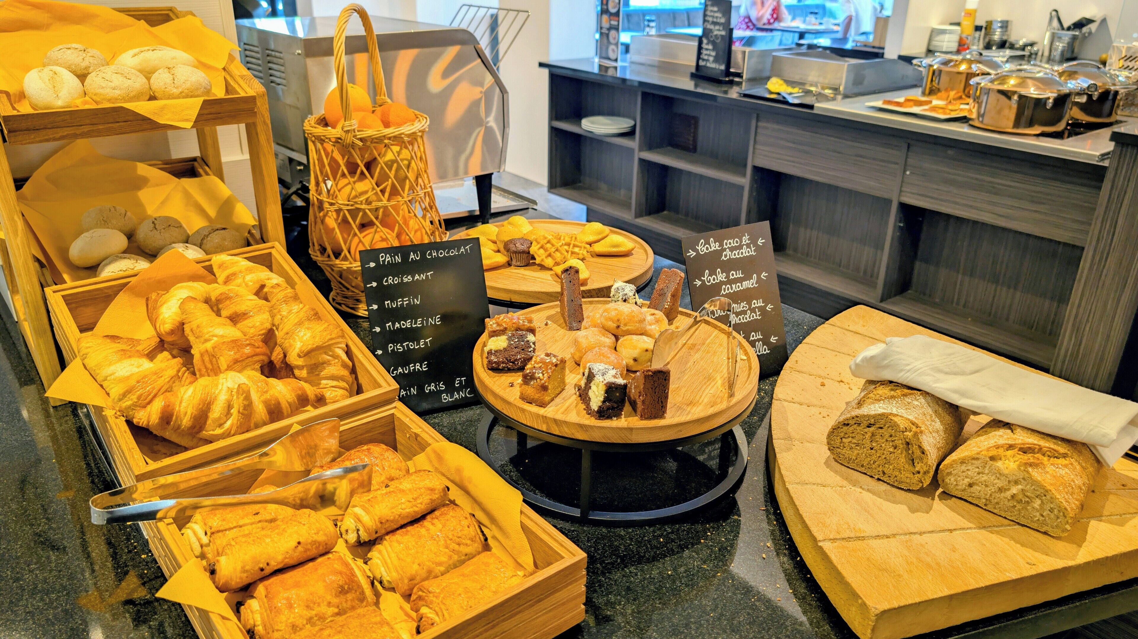 A bakery display with various baked goods like croissants, muffins, and bread.