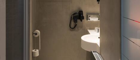 Un baño moderno con ducha, inodoro y lavamanos.