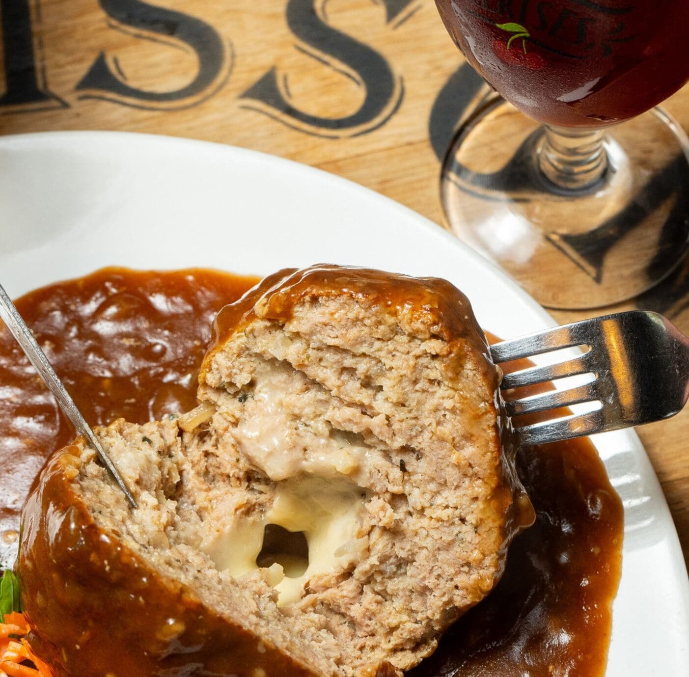 A meatloaf with gravy on a white plate.