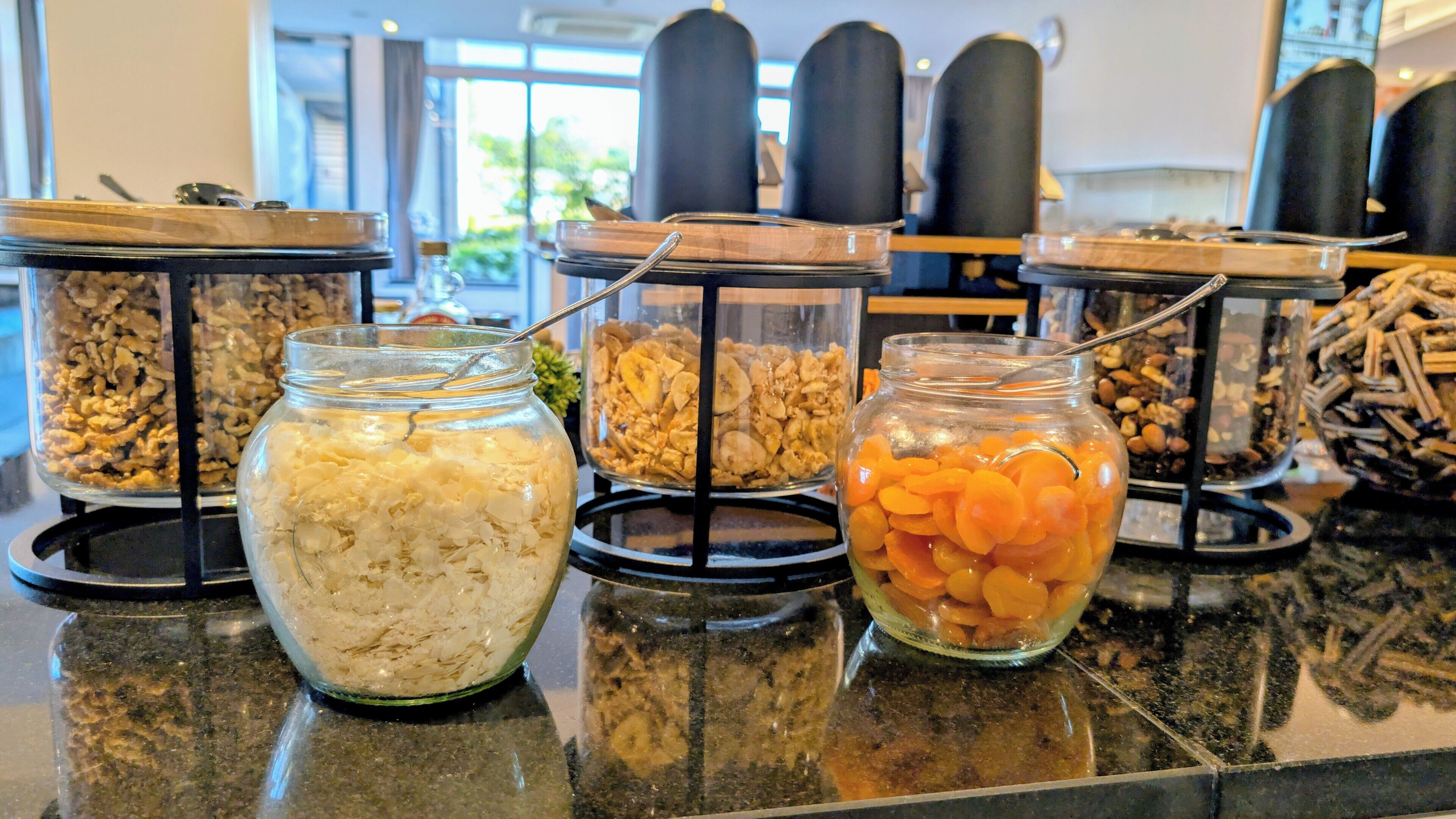 A buffet with various food items in glass containers on a counter.