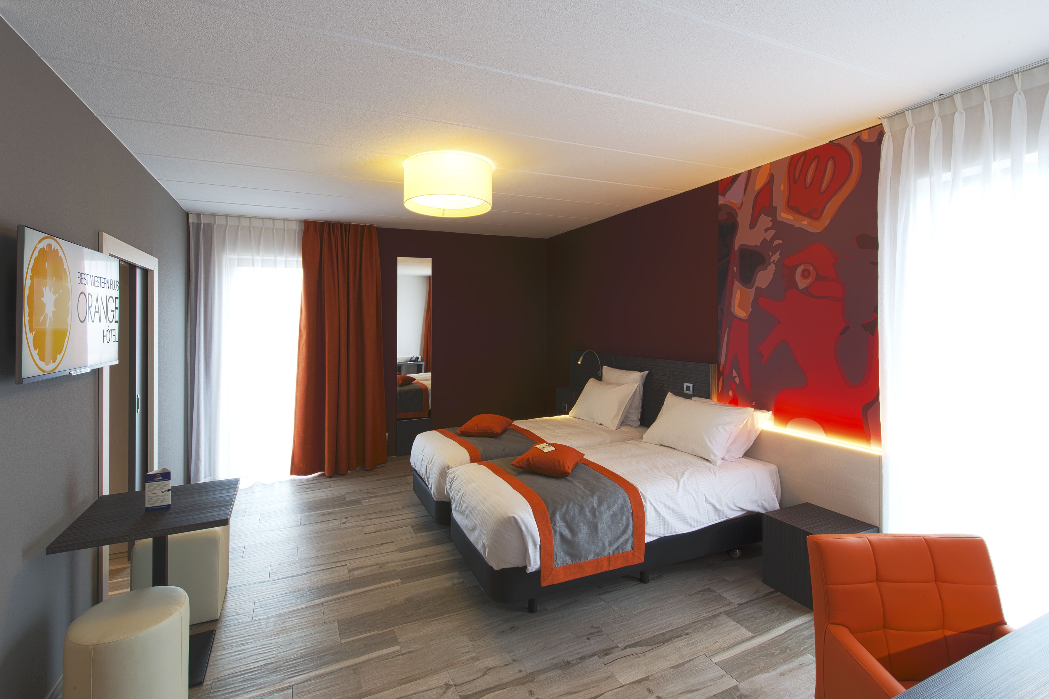 Une chambre d’hôtel moderne avec un grand lit, un bureau et une chaise.