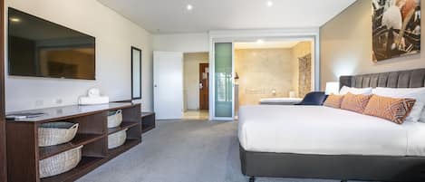 Un dormitorio moderno con una cama grande, un tocador con espejo y un vestidor.