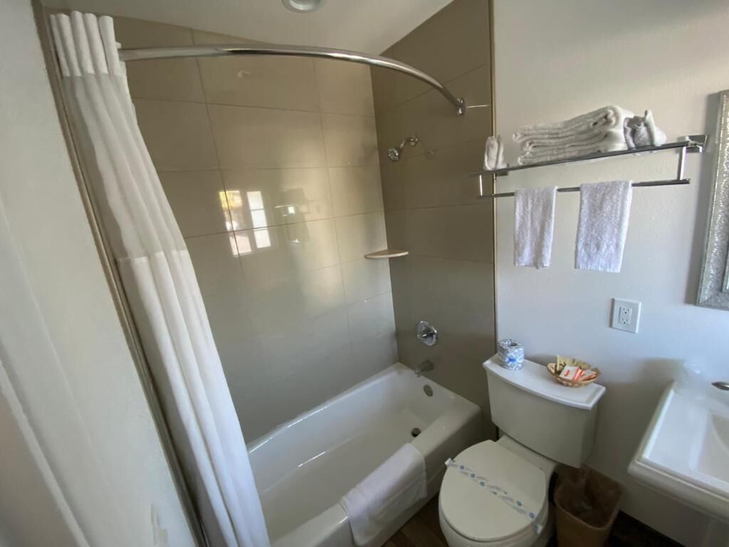 A bathroom with a bathtub, toilet, and sink.