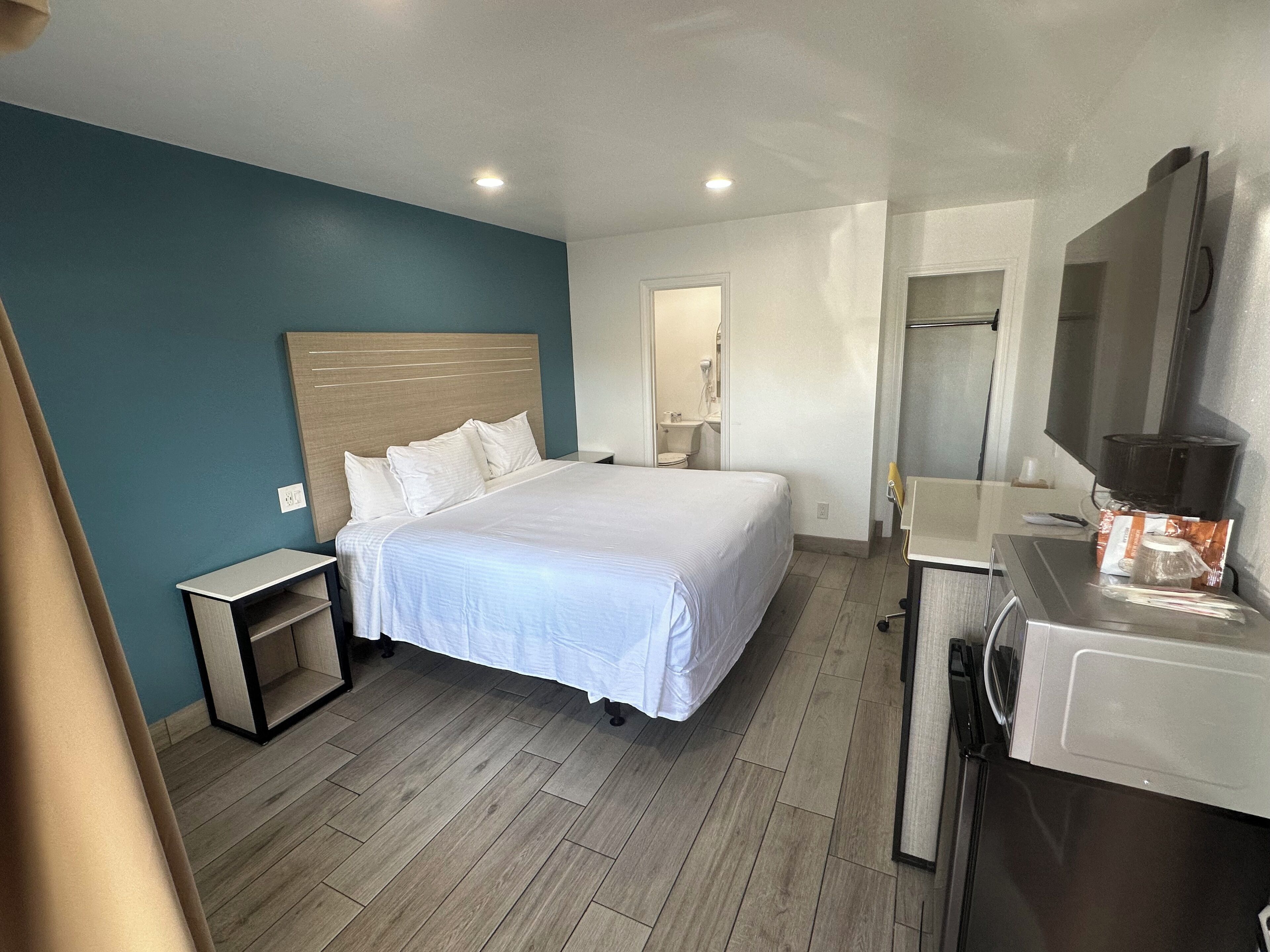 Une chambre d’hôtel équipée d’un lit, d’une table de chevet et d’un bureau avec un ordinateur.