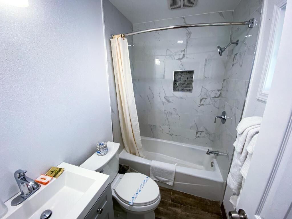 Un bagno con doccia, WC e lavandino.