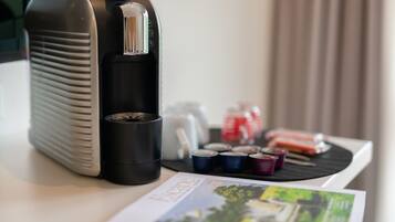 A coffee maker, a magazine, and some small containers on a table.
