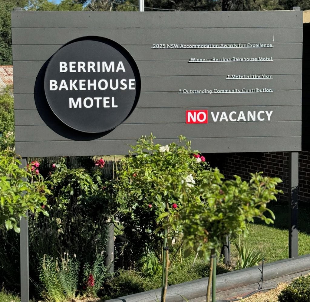 Een bordje voor Berrima Bakehouse Motel, met vermelde onderscheidingen en een 'VOL' bord.