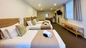 A hotel room with two beds, a small kitchenette, a TV, and a window with curtains. - Berrima Bakehouse Motel (Berrima)