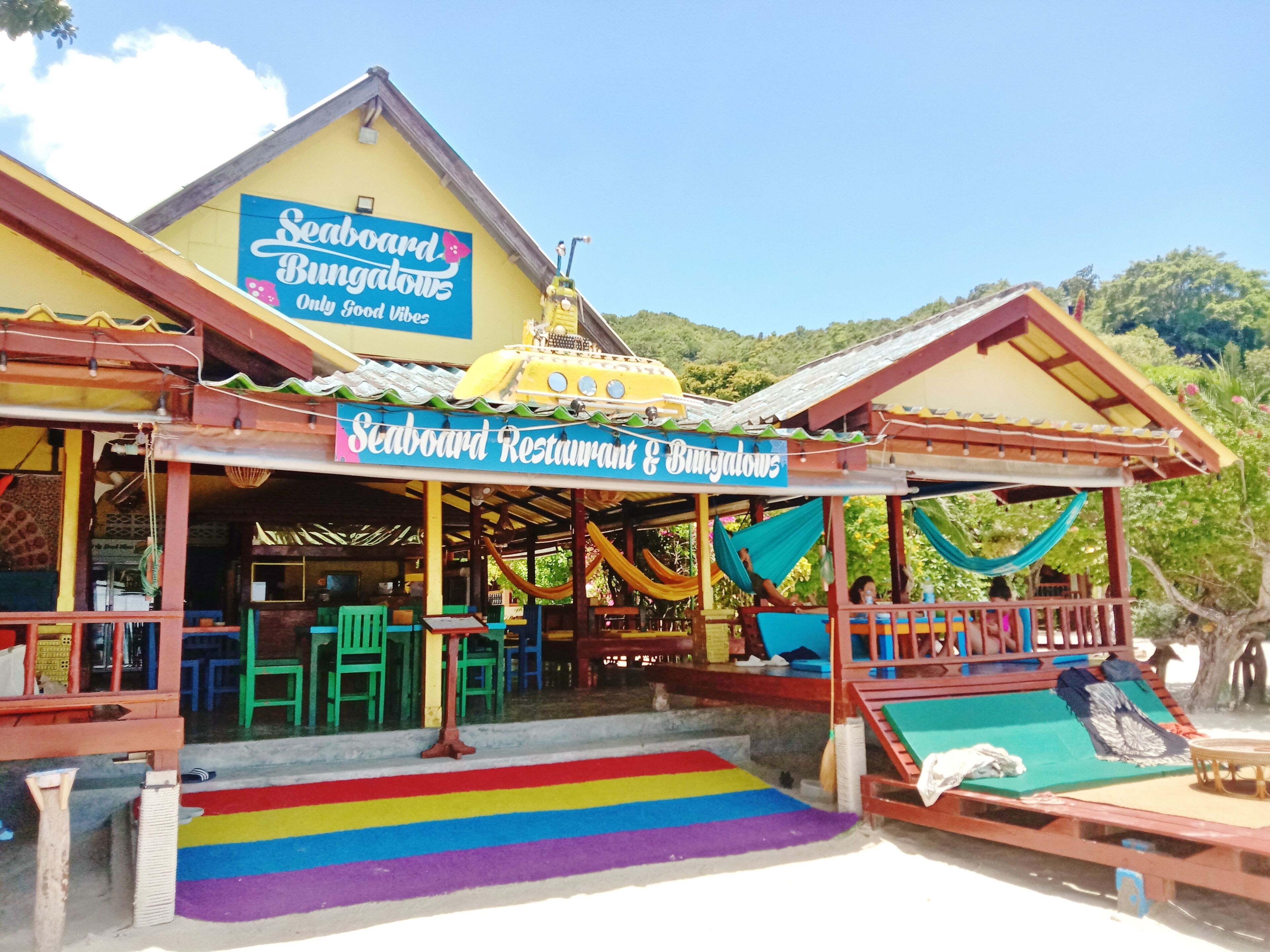 A beachside restaurant with a colorful exterior and a sign reading "Seaboard Restaurant & Bungalows".