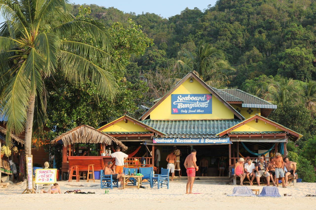 A beachside restaurant with a thatched roof and a sign reading "Seaboard Restaurant & Bungalows".