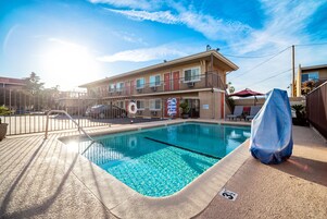 Una piscina al aire libre, sillones reclinables de piscina