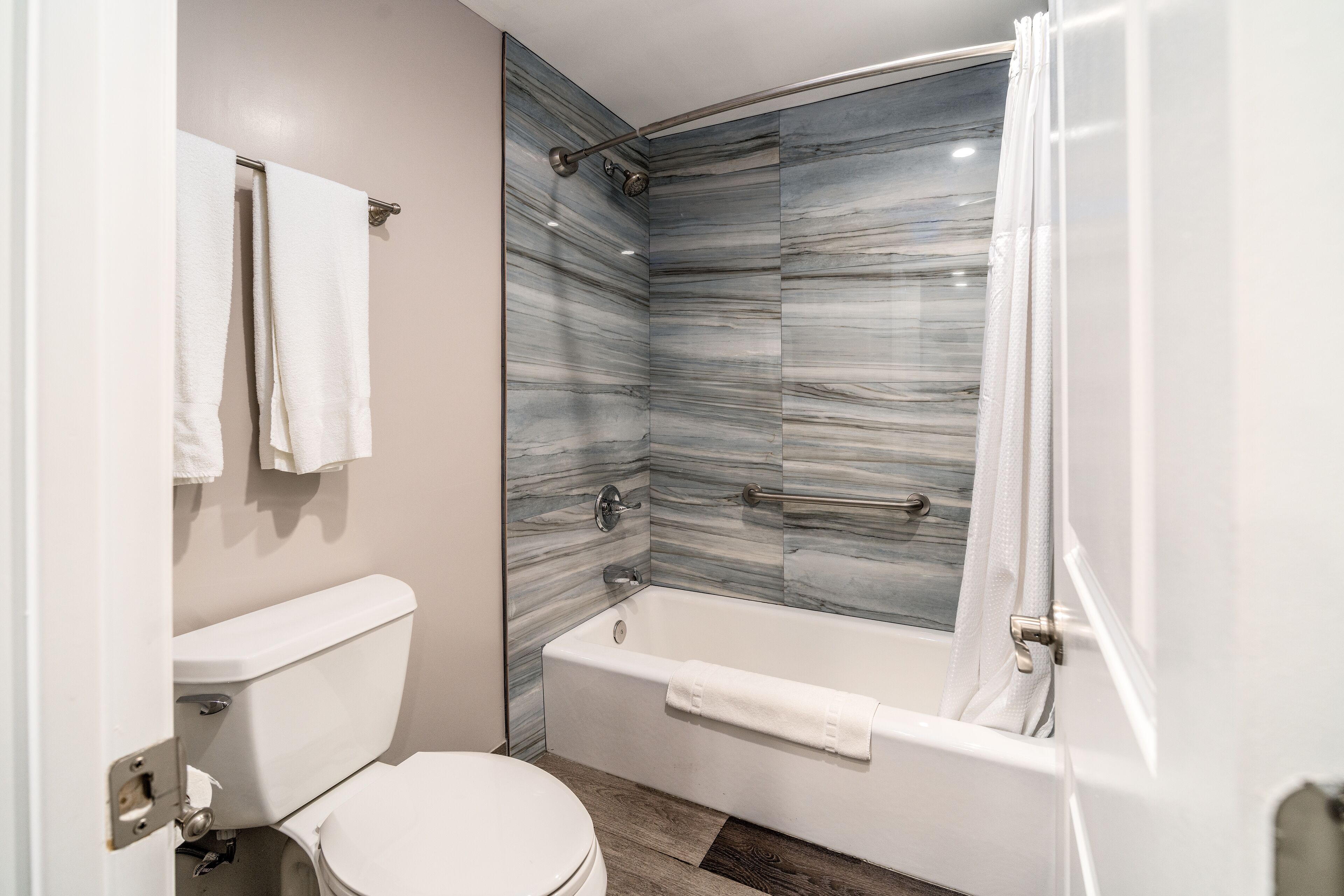 Un baño con inodoro, bañera y ducha con cortina.