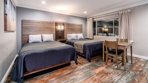 Une chambre d’hôtel avec deux lits, un bureau et une chaise.