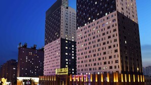 A modern hotel with a prominent entrance, multiple floors, and a busy street in the background. - Haiyun Jin Jiang Internatonal Hotel (Shenyang)