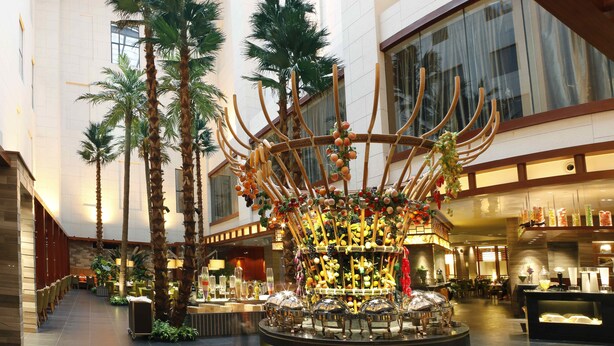 A spacious lobby with a central decorative structure, palm trees, and a modern interior design. - Haiyun Jin Jiang Internatonal Hotel (Shenyang)