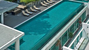 A rooftop swimming pool with lounge chairs and a modern architectural design. - Damas Suites & Residences (Kuala Lumpur)