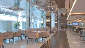 A modern interior with glass partitions, a long counter, and seating areas. - Damas Suites & Residences (Kuala Lumpur)