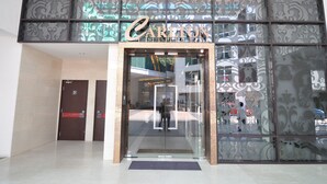 A Carlton hotel entrance with a glass door and a decorative facade. - Damas Suites & Residences (Kuala Lumpur)