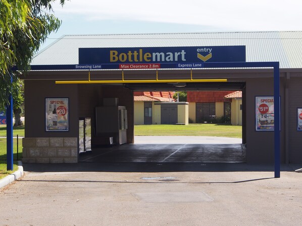 Entrada da BottleMart com sinalização para a corredora de consulta e corredor expresso, e altura máxima de 2,8m.