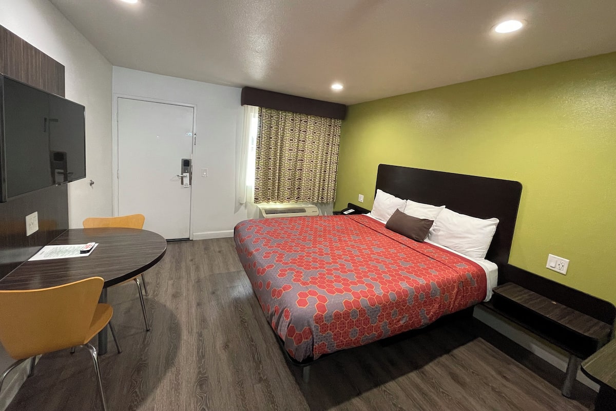 A hotel room with a bed, a desk, and a chair.