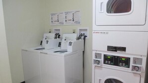 A laundry room with two front-loading washing machines and a stacked dryer. - Claremont Lodge (Claremont)