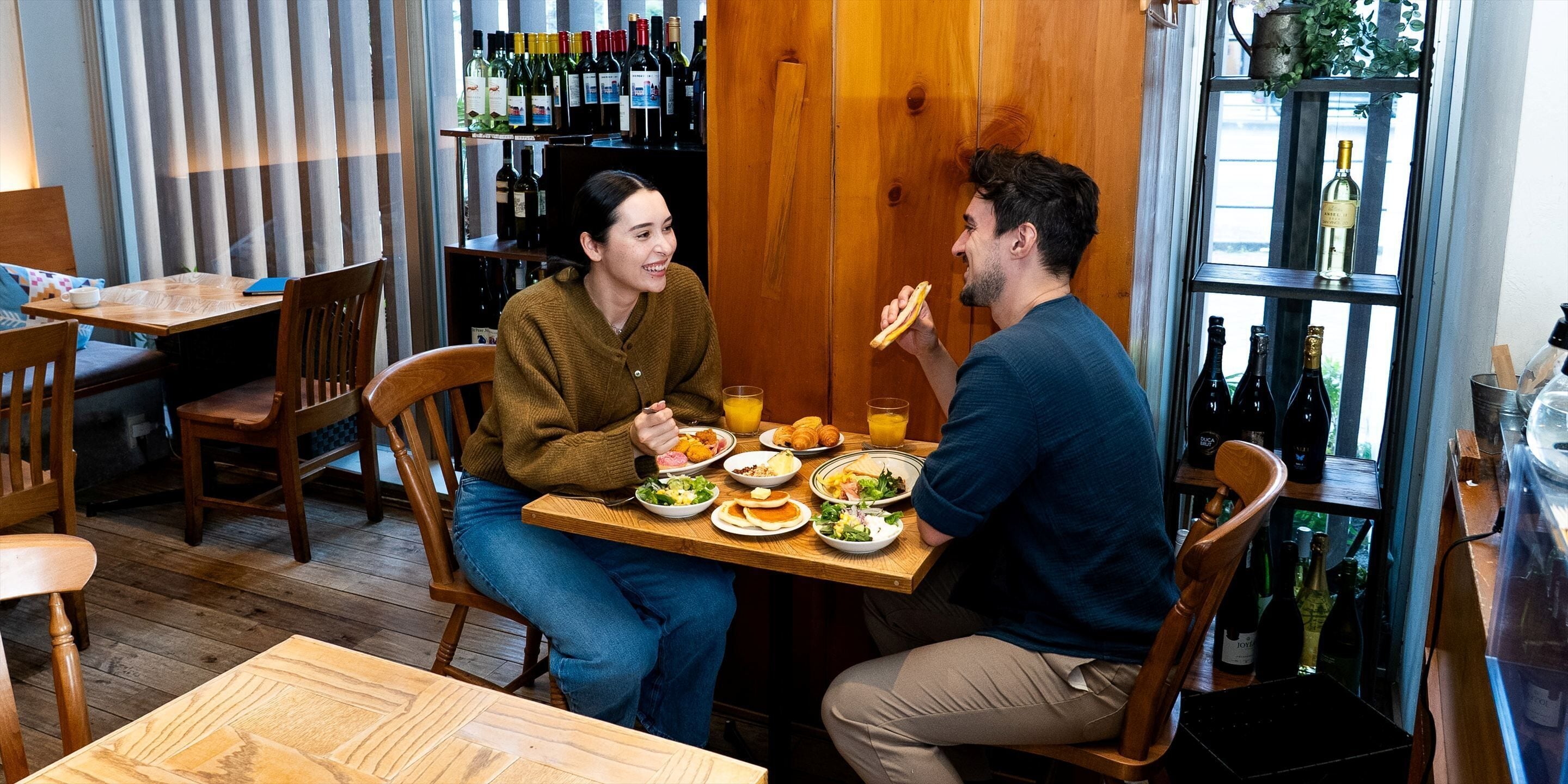 Un comedor con muebles de madera, una mesa con platos de comida y una estantería para vinos al fondo.