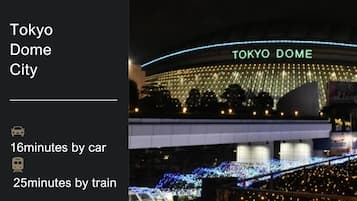 Tokyo Dome City con una gran estructura iluminada y un puente.