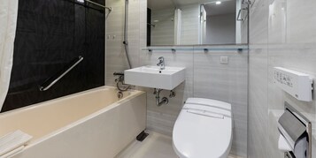 Egy modern fürőszoba, amelyben kád, mosdókagyló és WC található.