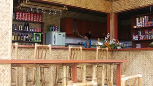 A restaurant with a bamboo exterior, a counter with a refrigerator, and shelves stocked with beverages and snacks. - Boracay Actopia Resort (Boracay Island)