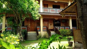 A traditional two-story building with a wooden facade, a balcony, and a staircase leading to the upper level. - Boracay Actopia Resort (Boracay Island)
