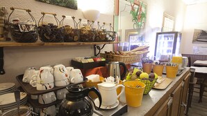A kitchen counter with various utensils, a coffee maker, and a fruit basket.