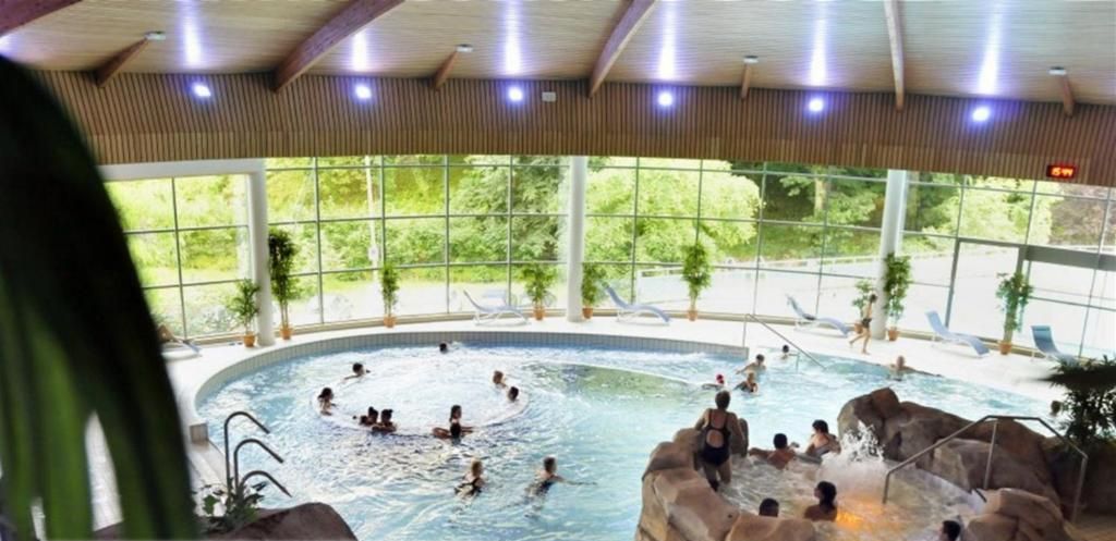 Una piscina interior con múltiples fuentes y un diseño natural.