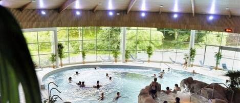 Una piscina interior con múltiples fuentes y un diseño natural.