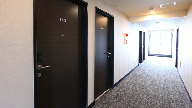 A hallway with two doors, one labeled 1102 and another 1104, leading to rooms. - Urbain Tokyo Haneda Kamata (Tokyo)