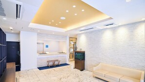 A hotel lobby with a reception desk, a sofa, a fish tank, and a marble floor. - Urbain Tokyo Haneda Kamata (Tokyo)
