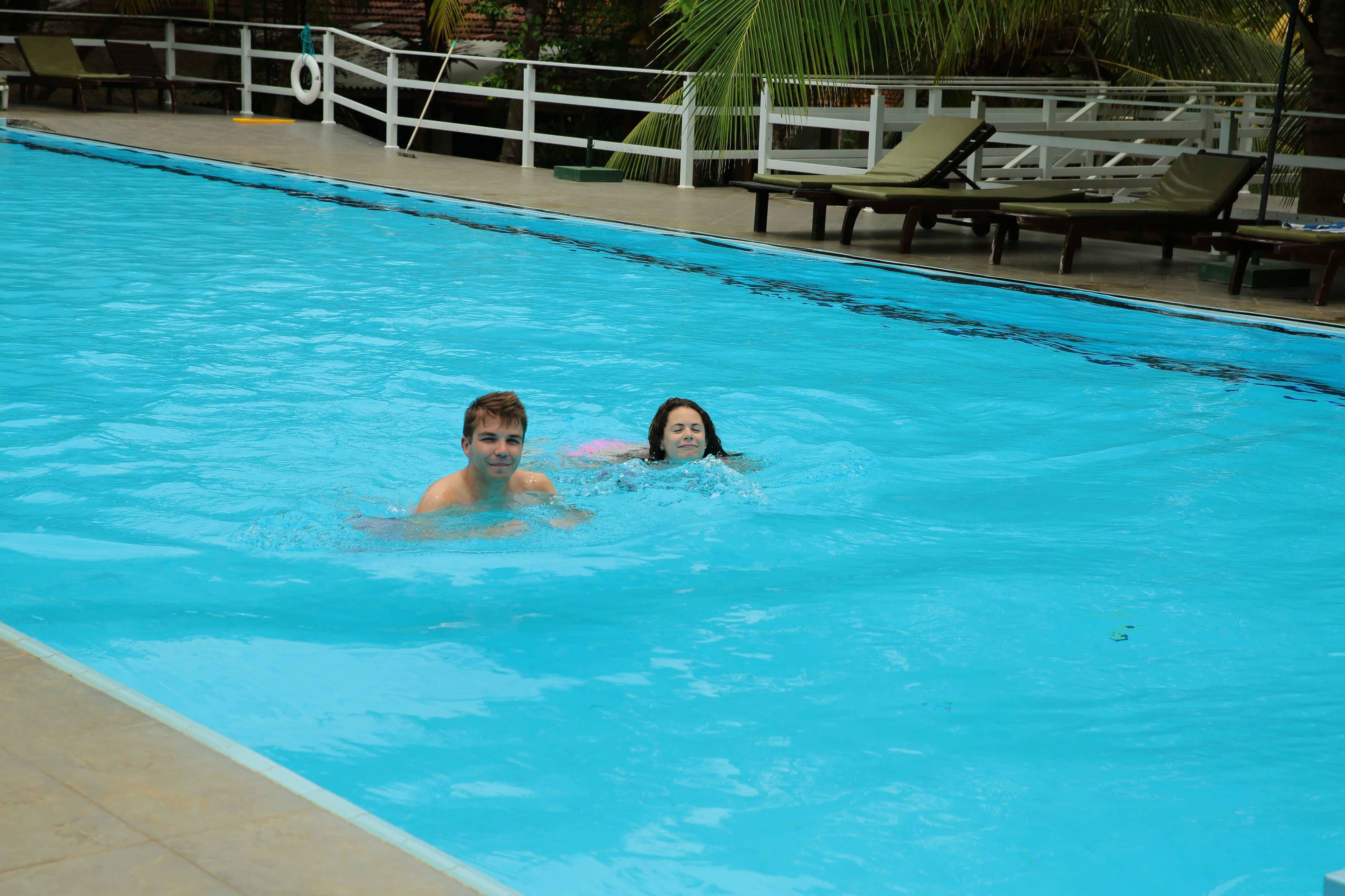 A swimming pool with lounge chairs and a lifebuoy.
