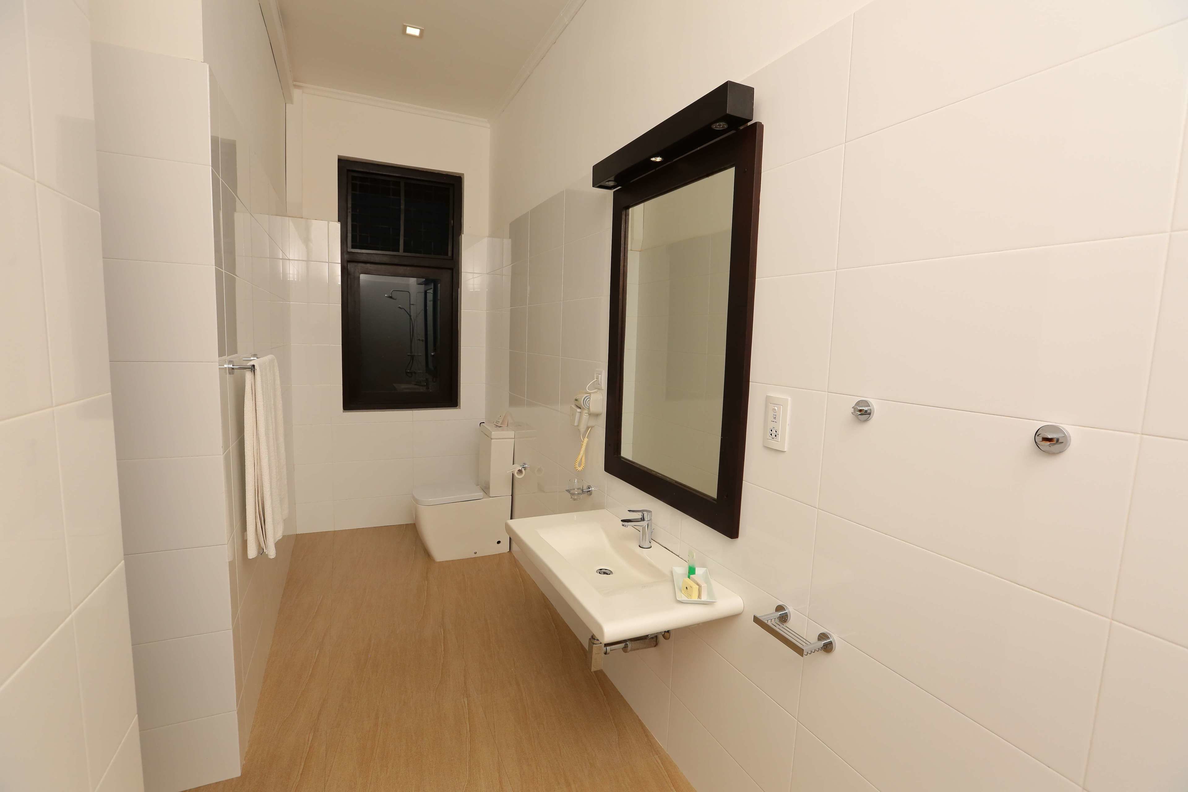 A modern bathroom with a white sink, a mirror, and a shower.