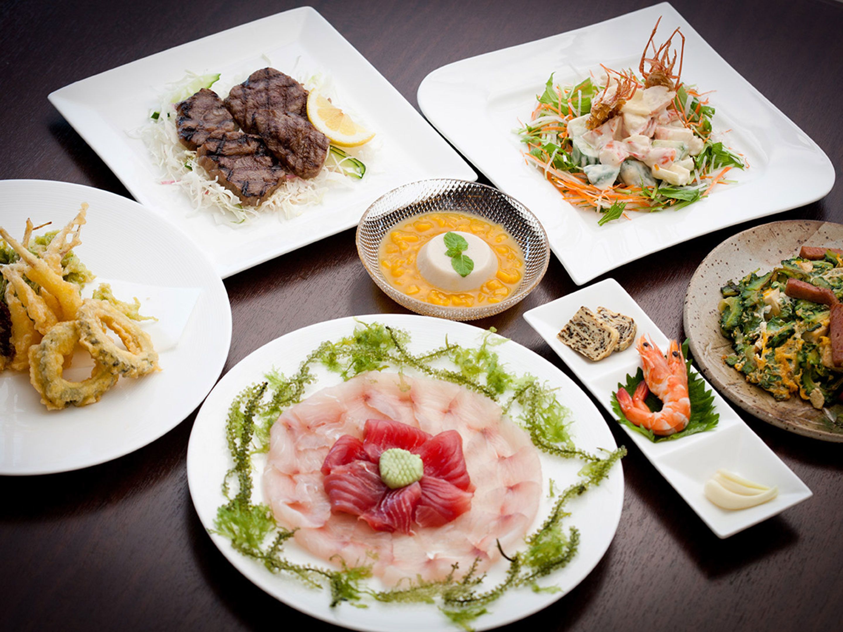 Une variété de plats sont disposés sur la table, notamment des fruits de mer, des salades et un dessert.
