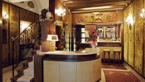 Zona de bar con mostrador curvo, taburetes y una pared decorativa.