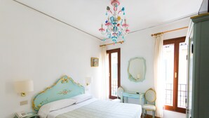 Un dormitorio con cama, mesita de noche, silla, cómoda y candelabro.